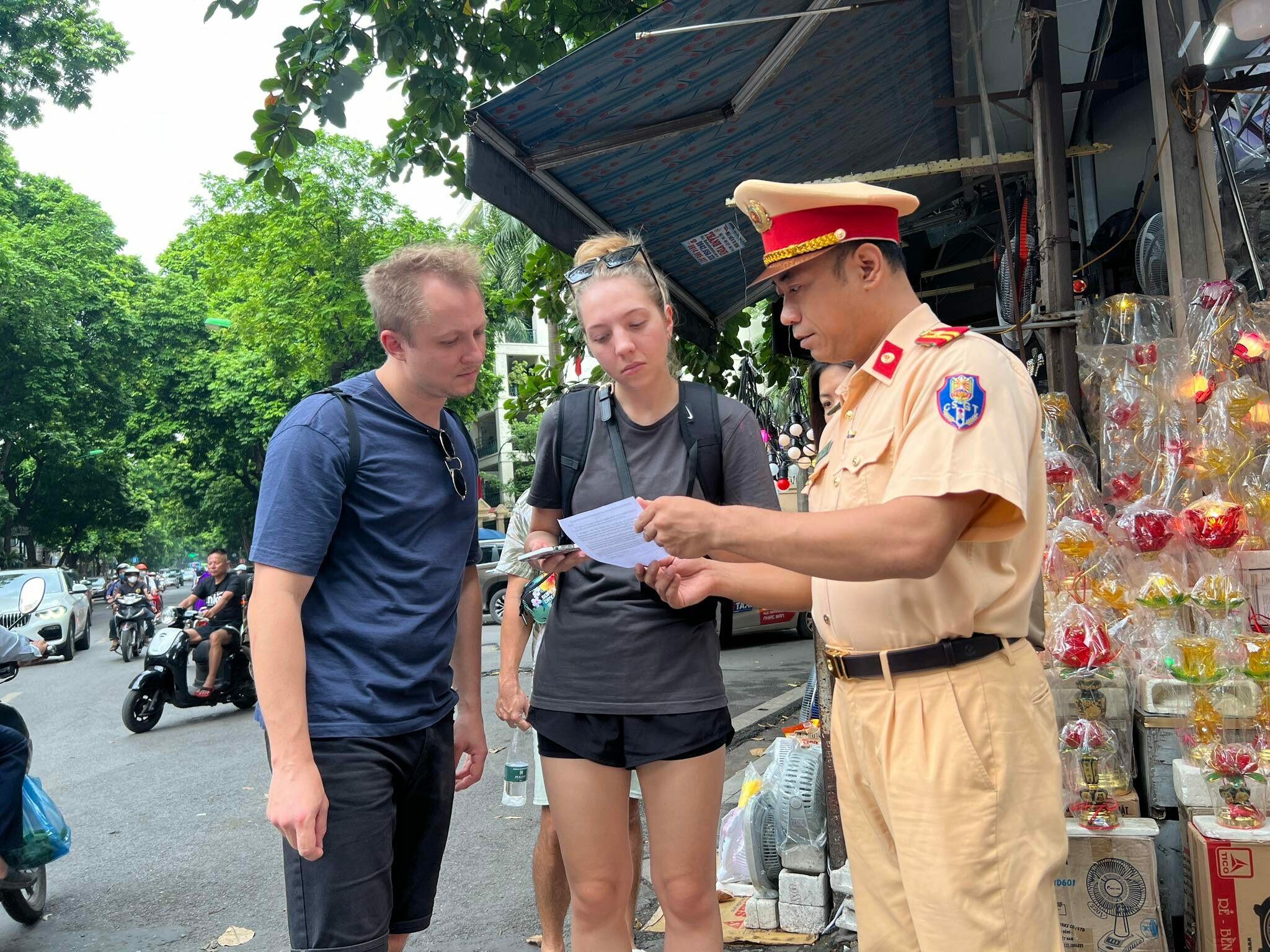Đ&acirc;y l&agrave; hoạt động nhằm đảm bảo an ninh, an to&agrave;n đường sắt.  Ảnh: C&aacute;n bộ CSGT H&agrave; Nội hướng dẫn du kh&aacute;ch nước ngo&agrave;i về c&aacute;c quy định ph&aacute;p luật trật tự ATGT đường sắt v&agrave; th&ocirc;ng tin để du kh&aacute;ch nắm được, kh&ocirc;ng đi v&agrave;o chụp ảnh tại khu vực c&agrave; ph&ecirc; đường t&agrave;u.