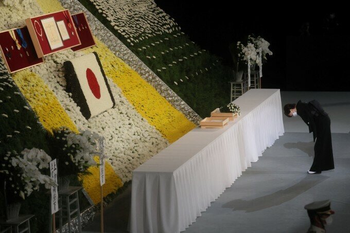 Phu nhân Akie Abe đặt hoa, c&uacute;i đầu tiễn biệt chồng.