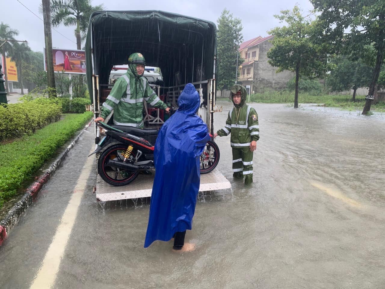 Lực lượng CSGT phải đưa xe chuy&ecirc;n dụng gi&uacute;p người d&acirc;n đi qua đoạn ngập