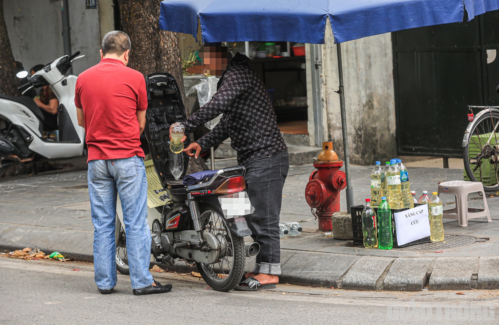 Đ&aacute;ng ch&uacute; &yacute;, ngay cạnh cửa h&agrave;ng n&agrave;y xuất hiện điểm b&aacute;n xăng tự ph&aacute;t. Cụ thể, xăng được chứa trong c&aacute;c chai nhựa để tiện b&aacute;n lại cho người đi đường.