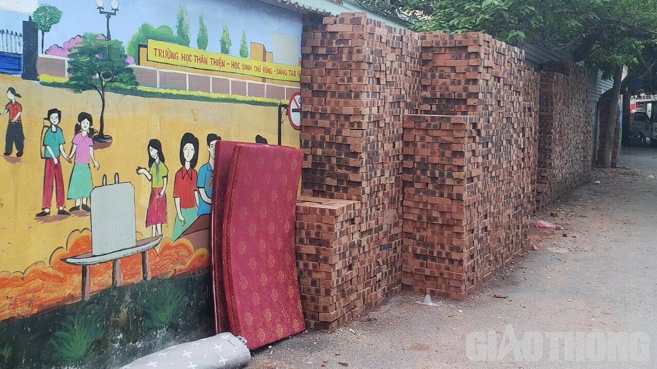 Cụ thể, tại ng&otilde; 342 đường Khương Đ&igrave;nh, những đống gạch được xếp cao khoảng hơn 2m nằm rải r&aacute;c ở mọi vị tr&iacute; tr&ecirc;n đường, thậm ch&iacute; gạch được xếp cả ở những khu vực tường được vẽ tranh.