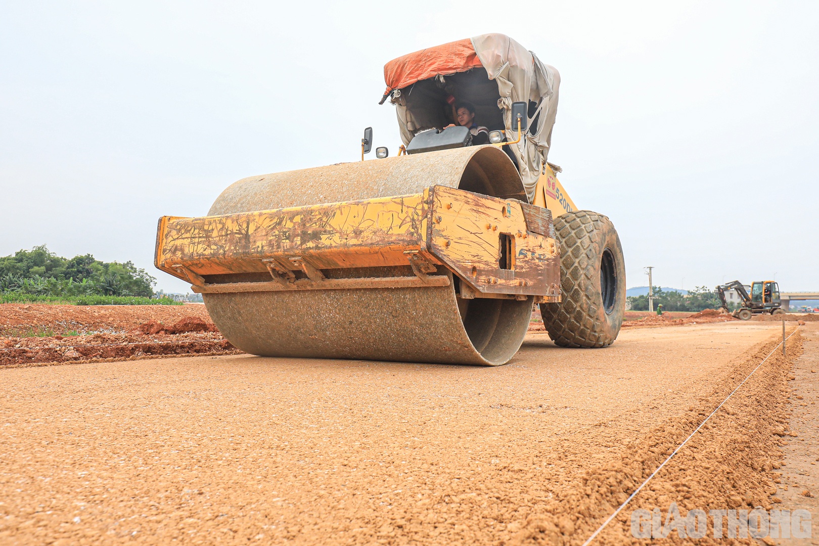 &ldquo;Tuy nhi&ecirc;n, những ng&agrave;y gần đ&acirc;y, nh&agrave; thầu đ&atilde; chấp nhận mua vật liệu từ những mỏ xa hơn (c&aacute;ch c&ocirc;ng trường 27 km) thay v&igrave; c&aacute;c mỏ dự kiến lấy ban đầu (c&aacute;ch c&ocirc;ng trường 15 km) để tăng tốc, b&ugrave; những phần việc bị chậm. Năng suất thi c&ocirc;ng CTB đ&atilde; được đẩy l&ecirc;n 800 m3/ng&agrave;y thay v&igrave; 300 - 400 m3 như thời gian trước. Việc thi c&ocirc;ng CTB hiện đ&atilde; được 1 km/7,3 km, dự kiến sẽ ho&agrave;n th&agrave;nh v&agrave;o ng&agrave;y 6/11&rdquo;, &ocirc;ng Bắc th&ocirc;ng tin. Trong ảnh: nh&agrave; thầu thi c&ocirc;ng cấp phối đ&aacute; dăm tại Km294+880.