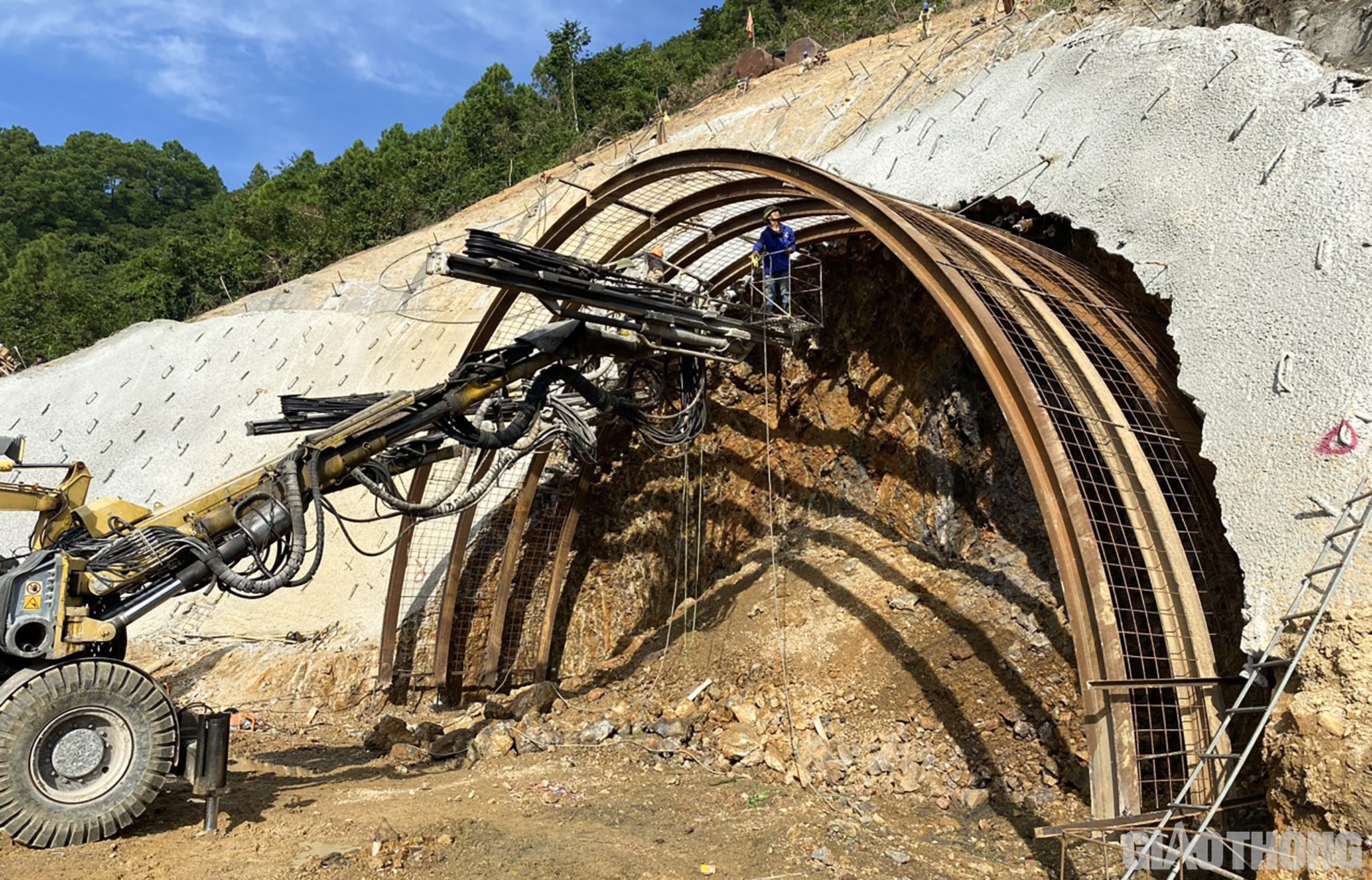 Ph&iacute;a Bắc mỗi ng&agrave;y khoan s&acirc;u được 2m, c&ograve;n ph&iacute;a Nam mỗi ng&agrave;y 1m. So với tiến độ đ&atilde; điều chỉnh, tiến độ ph&iacute;a Bắc đang vượt một ch&uacute;t, ph&iacute;a Nam do mưa gi&oacute; n&ecirc;n bị chậm tiến độ khoảng nửa th&aacute;ng. Ch&uacute;ng t&ocirc;i đang nỗ lực tăng ca, tăng k&iacute;p để b&ugrave; tiến độ. (Ảnh: Cửa hầm ph&iacute;a Nam hầm Thần Vũ)