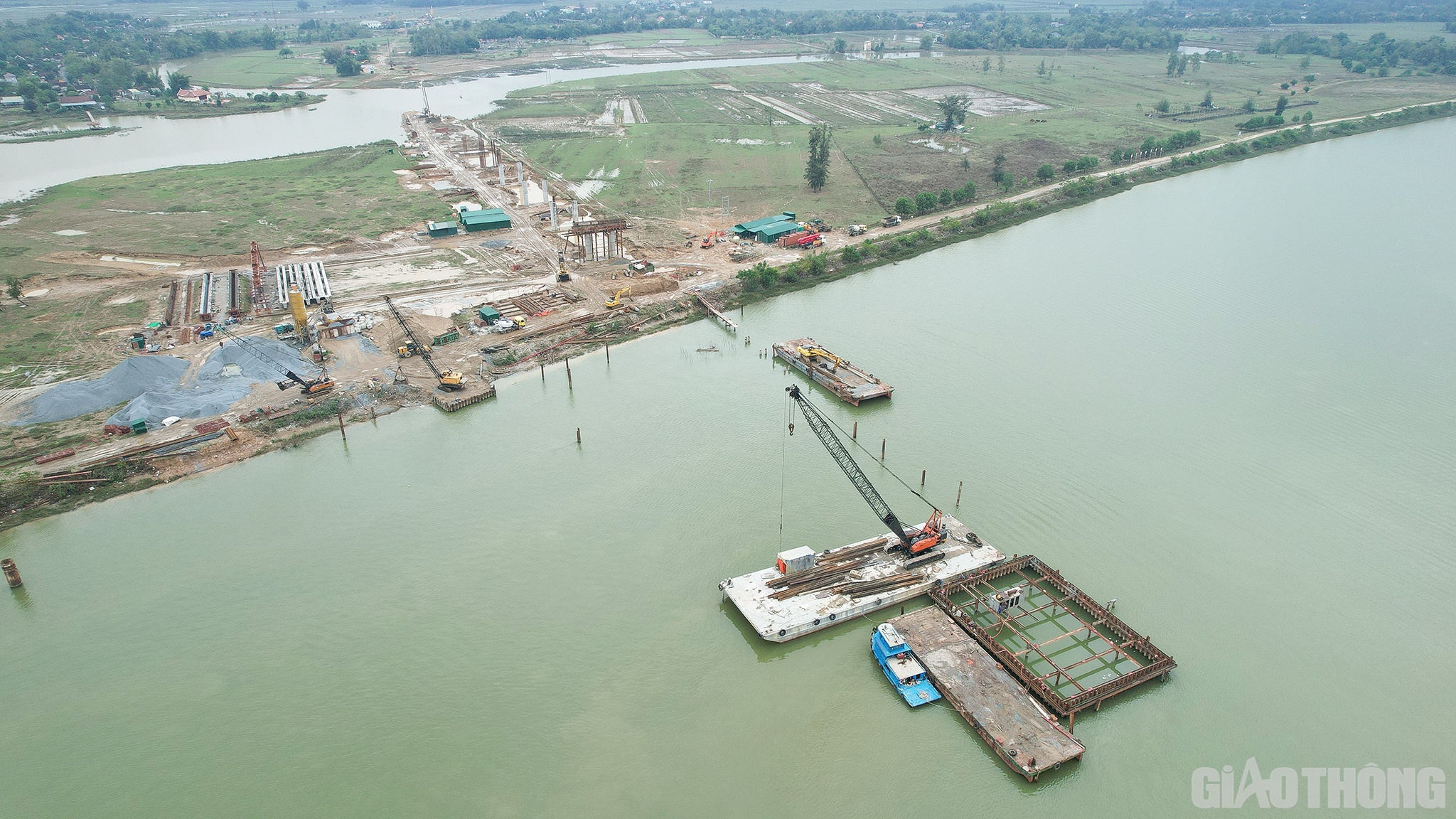 Kỹ sư Phạm Kh&aacute;nh Linh - Chỉ huy trưởng cầu vượt Hưng Đức, C&ocirc;ng ty TNHH Ho&agrave; Hiệp cho biết: Đơn vị triển khai thi c&ocirc;ng cầu Hưng Đức từ đầu th&aacute;ng 4/2022, ri&ecirc;ng ở ngo&agrave;i s&ocirc;ng Lam c&oacute; 3 trụ với 42 cọc khoan nhồi. Đến cuối th&aacute;ng 9/2022, đ&atilde; khoan xong hệ thống cọc nhồi, đang chuẩn bị thi c&ocirc;ng bịt đ&aacute;y th&igrave; mưa lũ về.