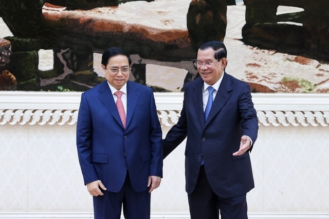 Thủ tướng Hun Sen mời Thủ tướng Phạm Minh Chính vào vị trí danh dự để bắt đầu lễ đón chính thức - Ảnh: VGP/Nhật Bắc