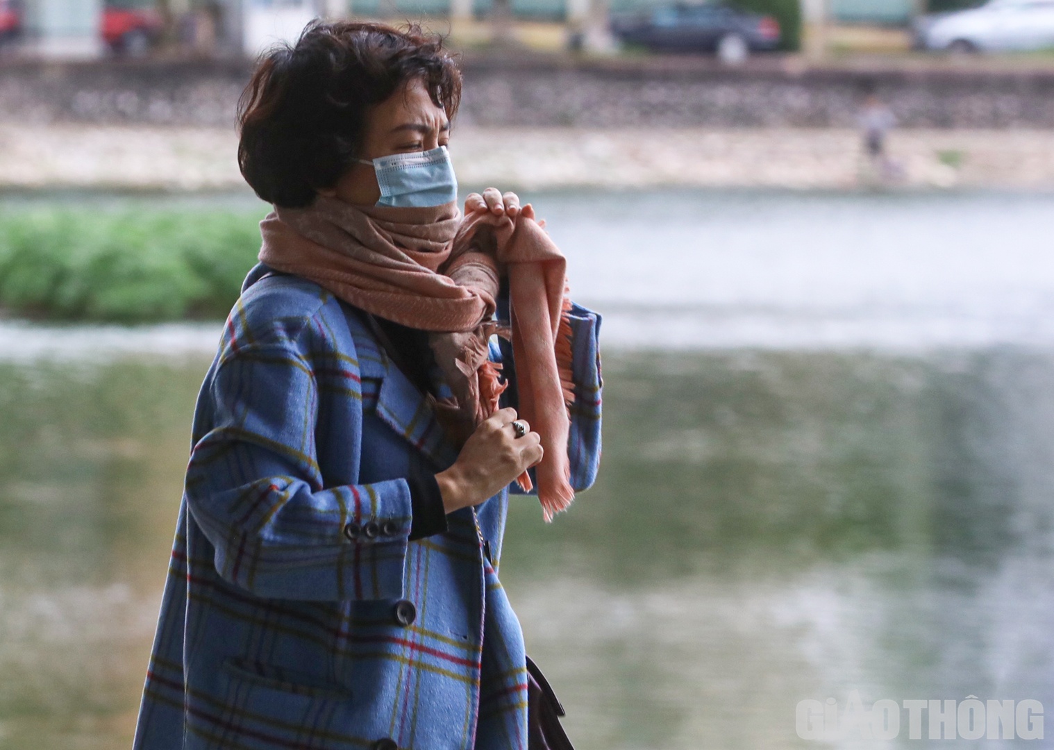 Người phụ nữ qu&agrave;ng th&ecirc;m khăn khi đi dạo quanh hồ Giảng V&otilde;.