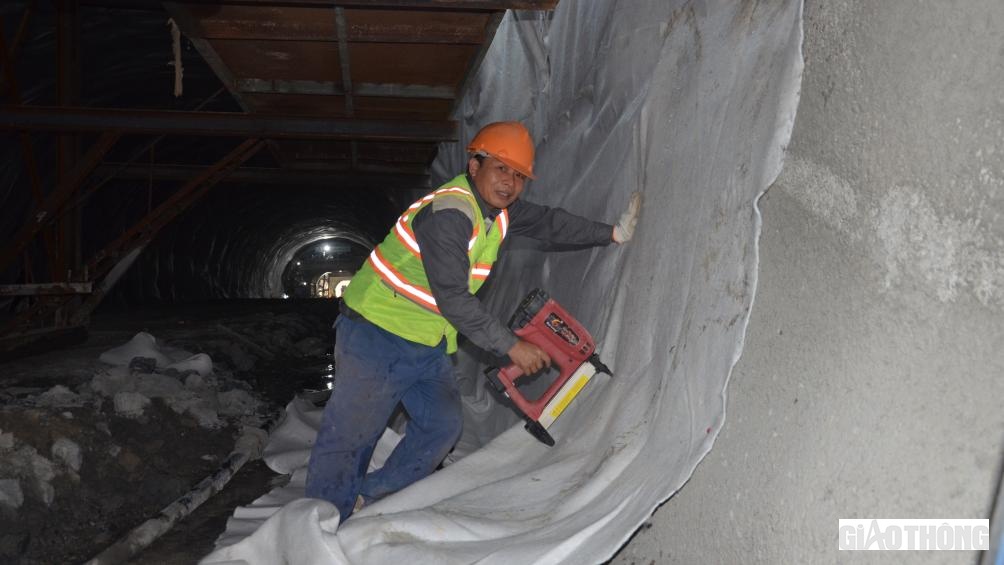 Anh Ng&ocirc; Phi Quyết (c&ocirc;ng nh&acirc;n Tập đo&agrave;n Đ&egrave;o Cả) cho biết: trong c&ocirc;ng đoạn l&agrave;m chống thấm v&agrave; gia cố m&aacute;i v&ograve;m, t&ocirc;i đảm nhận việc gắn vải địa l&ecirc;n v&aacute;ch. Mỗi ng&agrave;y tổ ch&uacute;ng t&ocirc;i bắn được khoảng 40m. Với 66 block, ch&uacute;ng t&ocirc;i phấn đấu xong trước Tết Nguy&ecirc;n đ&aacute;n.