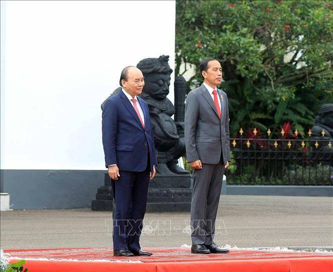 Trong tiếng nhạc ch&agrave;o mừng, Tổng thống Joko Widodo mời Chủ tịch nước Nguyễn Xu&acirc;n Ph&uacute;c bước l&ecirc;n bục danh dự. Qu&acirc;n nhạc cử Quốc thiều Việt Nam v&agrave; Quốc thiều Indonesia, c&ugrave;ng l&uacute;c đ&oacute;, nhiều loạt đại b&aacute;c ch&agrave;o mừng đ&atilde; vang l&ecirc;n, thể hiện sự coi trọng chuyến thăm cấp Nh&agrave; nước của Chủ tịch nước Nguyễn Xu&acirc;n Ph&uacute;c.