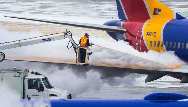 Nh&acirc;n vi&ecirc;n kỹ thuật l&agrave;m tan băng b&ecirc;n ngo&agrave;i m&aacute;y bay trước khi phương tiện chuẩn bị đ&oacute;n kh&aacute;ch. Ảnh - CNN