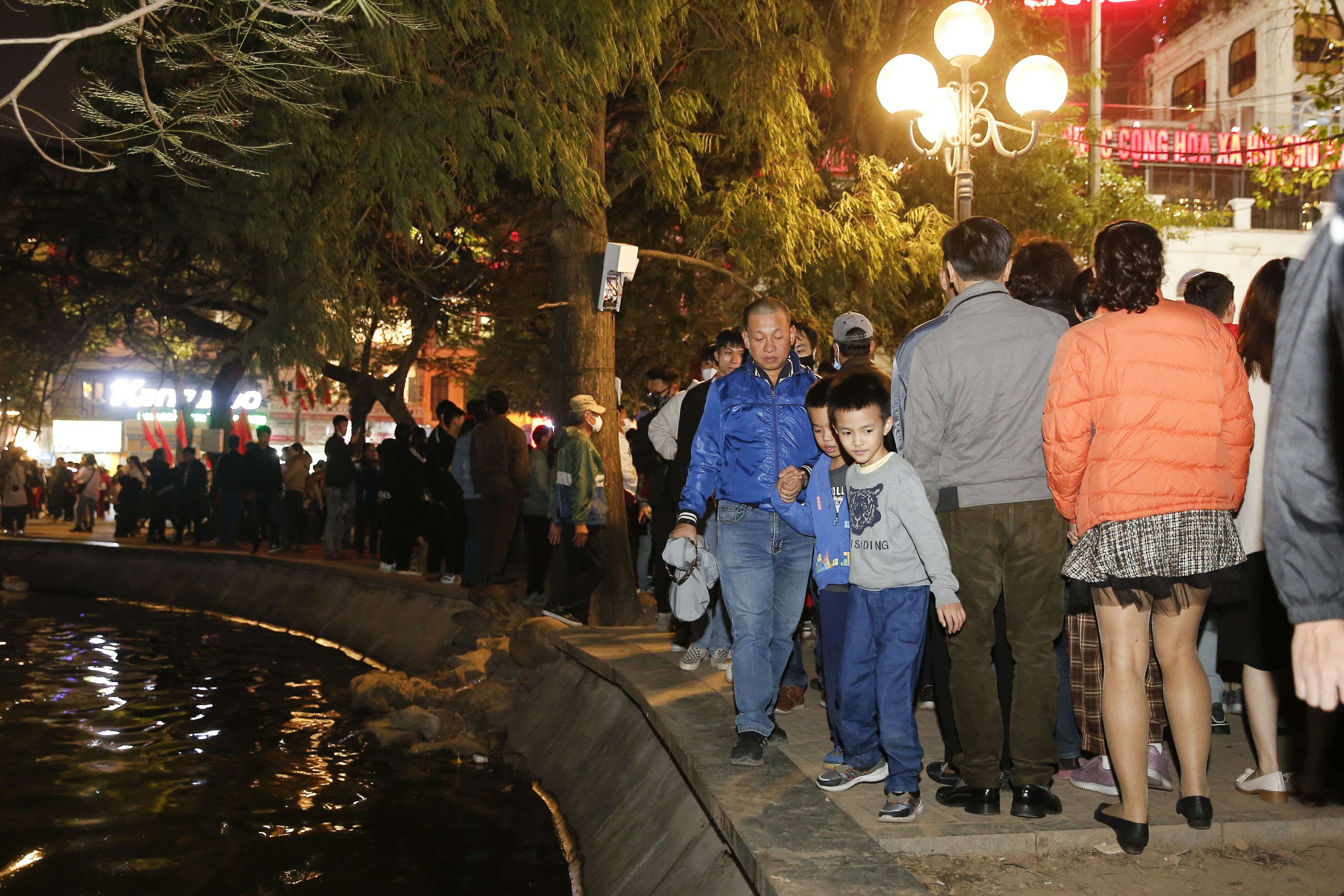 Khu vực đường đi bộ ven Hồ Gươm cũng chật n&iacute;ch người đi lại.