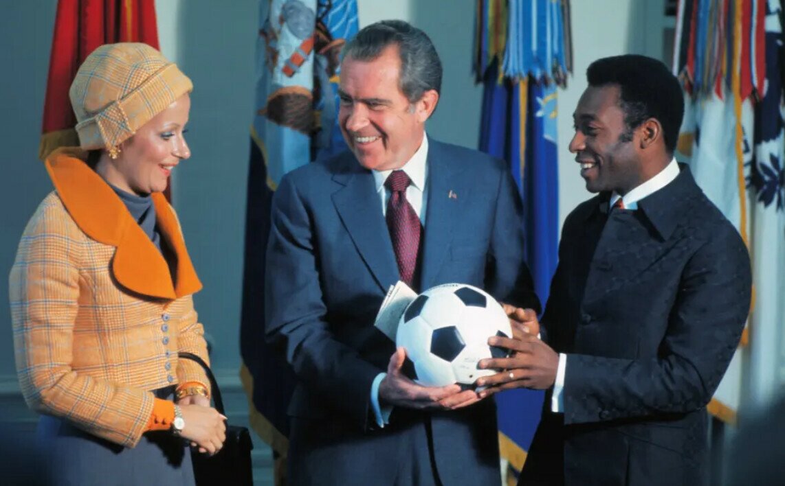 Pele chơi trận cuối cùng cho Santos vào tháng 10/1974. Ông định nghỉ hưu sau đó nhưng lời mời hấp dẫn của New York Cosmos cùng việc đám mây tài chính u ám đã khiến ông chọn chơi bóng cho đội bóng của Mỹ. Họ trả Pele 7 triệu đô la trong 3 năm với tư cách là một cầu thủ, cộng thêm 3 năm nữa với tư cách là Đại sư. Trong ảnh, ông đến thăm Tổng thống Nixon tại Nhà Trắng cùng với Rosemeri. Ảnh: Corbis