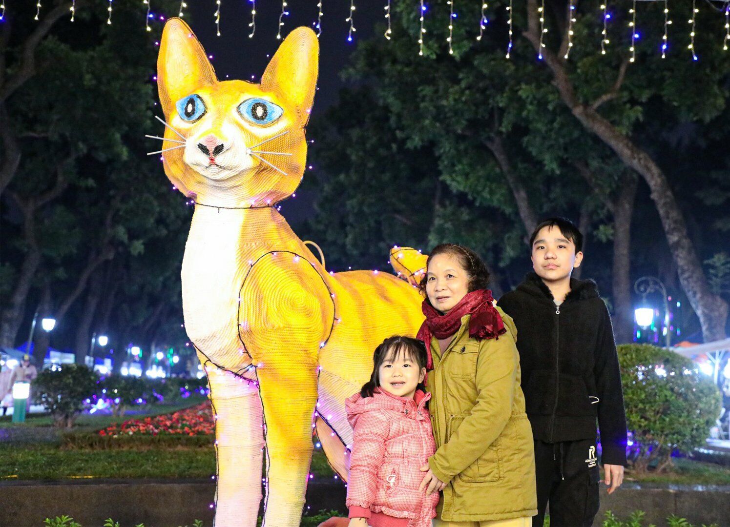 Một gia đình chụp ảnh cùng linh vật mèo vàng tại không gian phố đi bộ Trần Nhân Tông và các khu vực phụ cận.