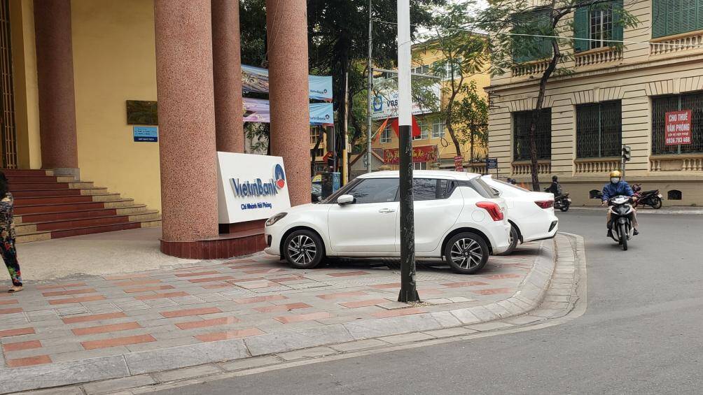 2 xe &ocirc; t&ocirc; v&ocirc; tư đỗ chắn ngang vỉa h&egrave; tại vị tr&iacute; trước cửa Ng&acirc;n h&agrave;ng VietinBank ở quận Ng&ocirc; Quyền.