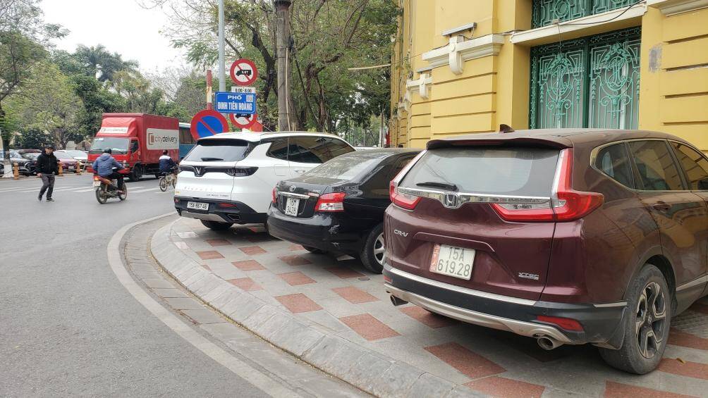 Tại vỉa h&egrave; ở đường Đinh Ti&ecirc;n Ho&agrave;ng, nhiều xe &ocirc; t&ocirc; dừng đỗ k&iacute;n khiến người đi bộ phải đi xuống l&ograve;ng đường, ảnh hưởng đến ATGT.