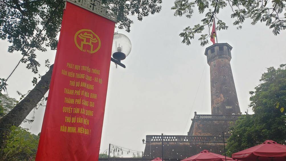 Cờ đỏ sao v&agrave;ng tung bay tr&ecirc;n di t&iacute;ch cột cờ.