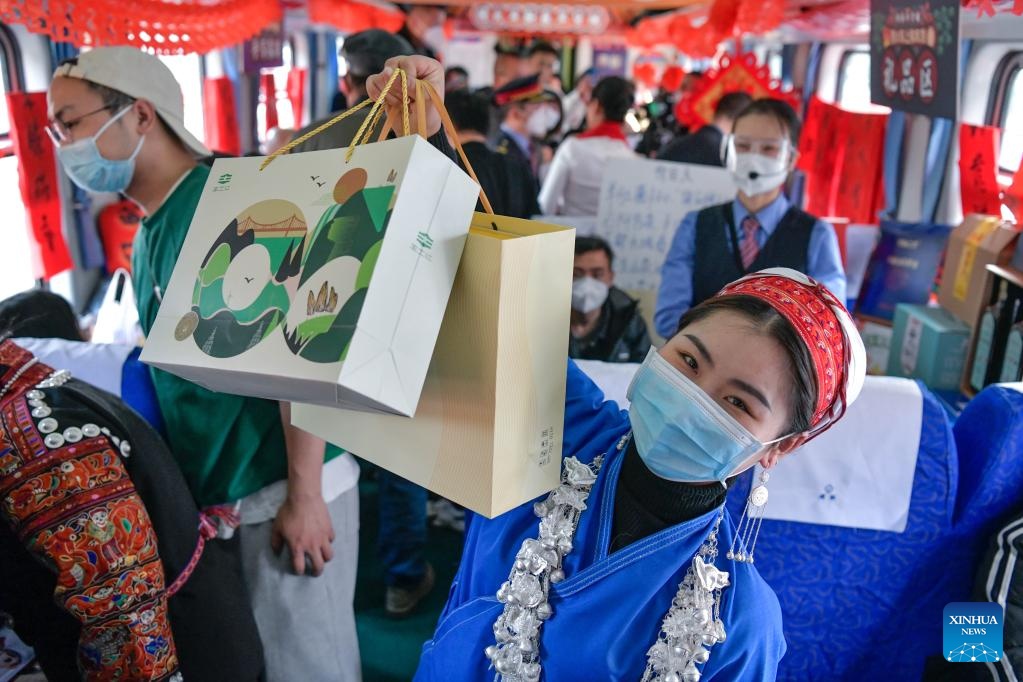 H&agrave;nh kh&aacute;ch tươi cười rạng rỡ với những m&oacute;n đồ mua được tại phi&ecirc;n chợ tết độc đ&aacute;o diễn ra tr&ecirc;n t&agrave;u. Ảnh: Xinhua