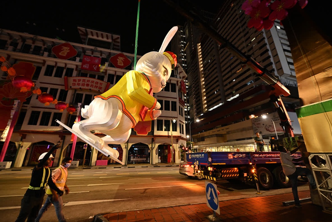 C&aacute;c c&ocirc;ng nh&acirc;n, sinh vi&ecirc;n, giảng vi&ecirc;n đại học Singapore phải sử dụng d&acirc;y thừng, cần cẩu để đưa những m&oacute;n đồ trang tr&iacute; l&ecirc;n độ cao cần thiết. Phải mất hơn 2 giờ, to&agrave;n bộ th&agrave;nh vi&ecirc;n trong gia đ&igrave;nh thỏ mới được đặt v&agrave;o vị tr&iacute; tr&ecirc;n bệ của khu vực trang tr&iacute; trung t&acirc;m tại khu phố Chinatown. Ảnh: Straits Times