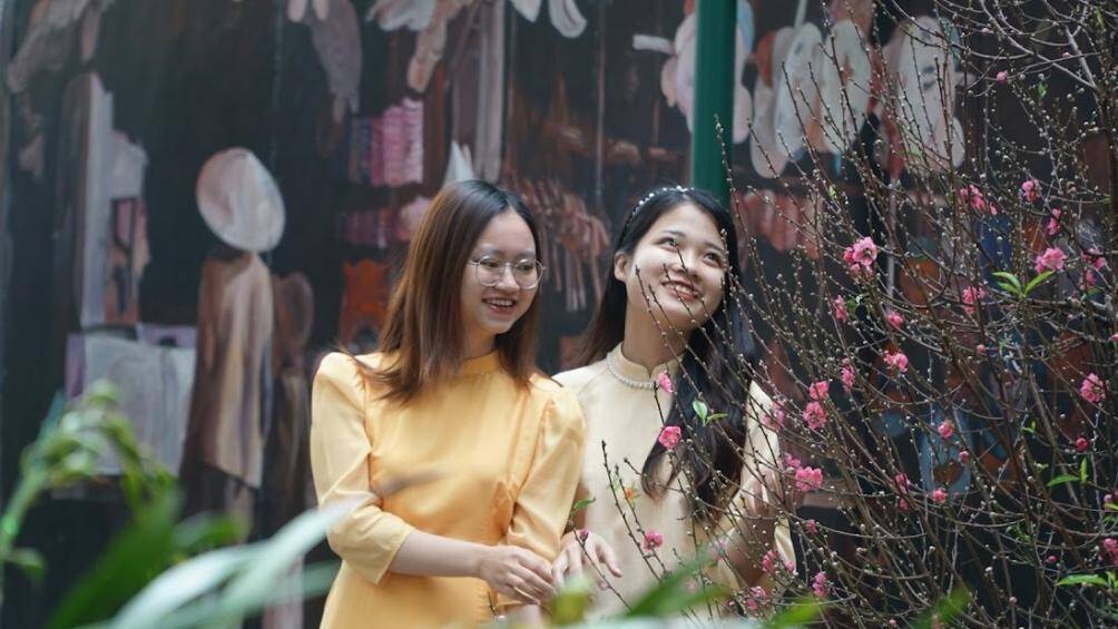 "Ch&uacute;ng m&igrave;nh chọn khu phố b&iacute;ch họa để chụp ảnh do tranh được vẽ rất đẹp, đa dạng về m&agrave;u sắc v&agrave; đường phố cũng được trang ho&agrave;ng mang đậm văn h&oacute;a H&agrave; Nội v&agrave; ngập kh&ocirc;ng kh&iacute; Tết", một nh&oacute;m c&aacute;c c&ocirc; g&aacute;i chia sẻ.