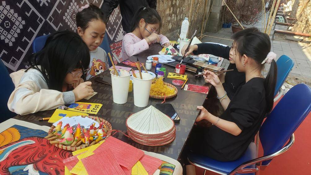 Những bạn trẻ tham gia hoạt động t&ocirc; m&agrave;u tr&ecirc;n vỉa h&egrave; phố b&iacute;ch họa Ph&ugrave;ng Hưng.