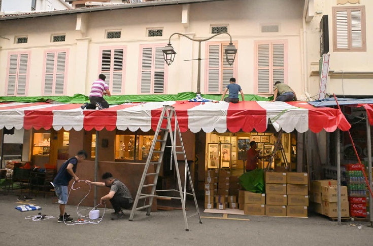 Rất nhiều gian h&agrave;ng với m&agrave;u đỏ v&agrave; trắng quen thuộc đ&atilde; được dựng l&ecirc;n tại phố Temple, b&agrave;y b&aacute;n v&ocirc; số những mặt h&agrave;ng phục vụ dịp Tết Nguy&ecirc;n đ&aacute;n. Hội chợ năm nay quy tụ 280 gian h&agrave;ng xếp k&iacute;n c&aacute;c d&atilde;y phố Smith, phố Pagoda, phố Trengganu v&agrave; phố Temple. Ảnh: Straits Times