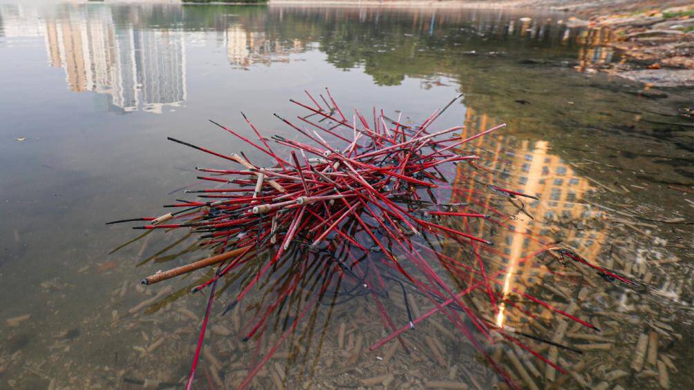 Phần c&ograve;n lại của que hương chất đống tr&ecirc;n mặt hồ.