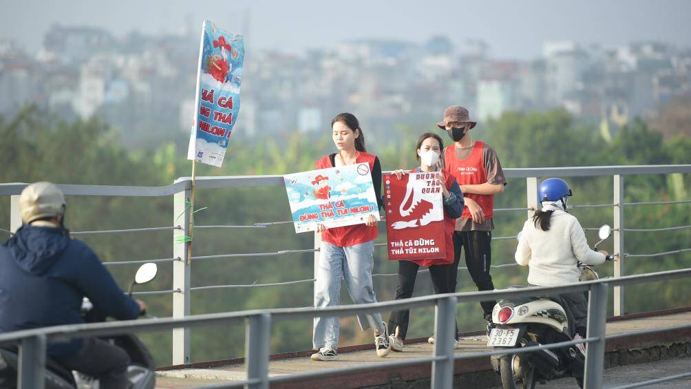 Cứ mỗi 1 đoạn ở 2 chiều tr&ecirc;n cầu Long Bi&ecirc;n, c&aacute;c bạn trẻ đều cầm biển "Thả c&aacute; xin đừng thả nilon".