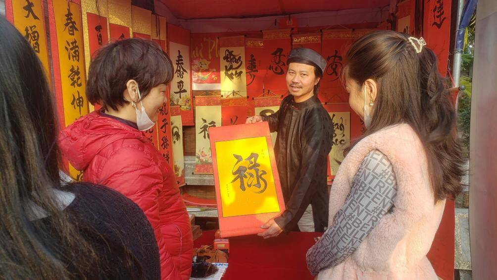 Nhiều du kh&aacute;ch tranh thủ xin chữ lộc đầu năm tại đền Trần để lấy may ng&agrave;y đầu năm mới.