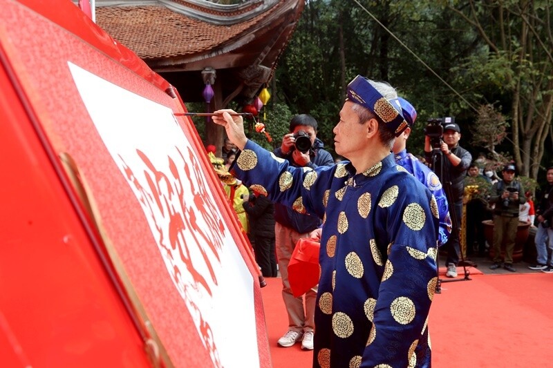 Nhà thư pháp Nguyễn Đình Kế trình diễn khai bút dòng chữ “Quốc – Thái – Dân - An” tại lễ khai bút ở đền thờ Chu Văn An.