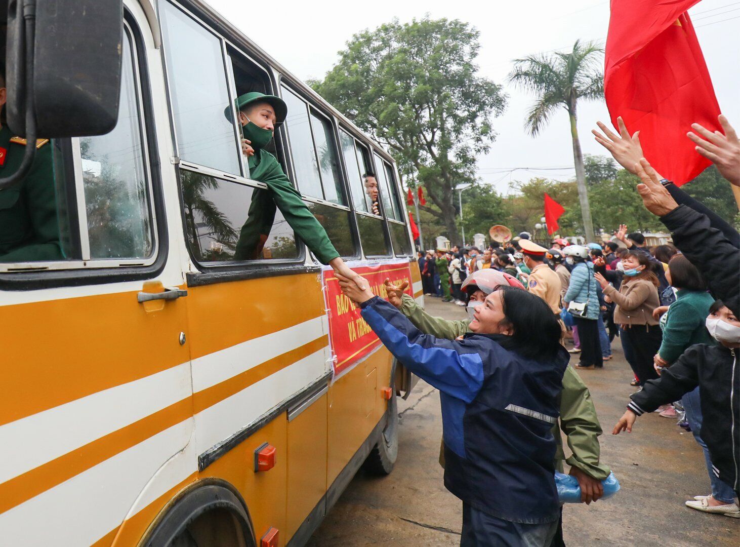 Xe đ&atilde; chuyển b&aacute;nh, nhiều người th&acirc;n vẫn cố chạy theo, nắm tay con em m&igrave;nh giờ đ&atilde; l&agrave; một t&acirc;n binh l&ecirc;n đường nhập ngũ.