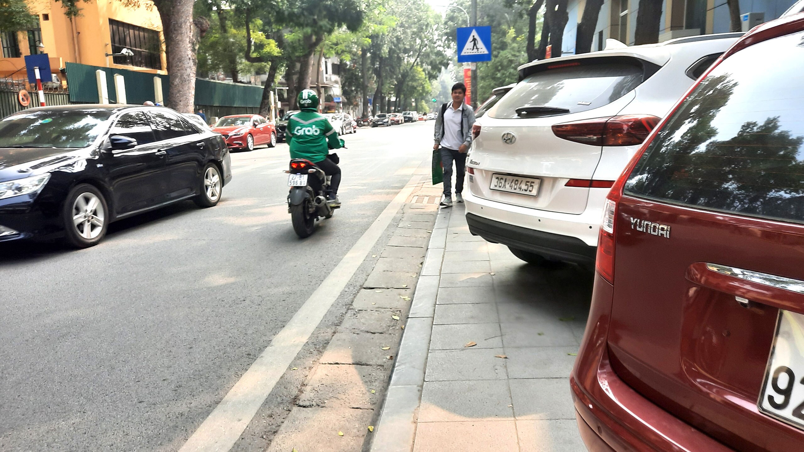 Nhiều người muốn đi bộ qua đ&acirc;y phải nghi&ecirc;ng người, luồn l&aacute;ch qua những chiếc &ocirc; t&ocirc; mới c&oacute; thể đi được.