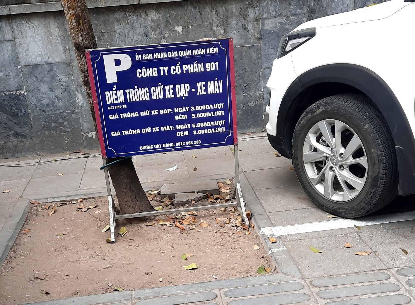 Tại vỉa h&egrave; tr&ecirc;n phố Trần B&igrave;nh Trọng c&oacute; bảng hiệu ghi điểm tr&ocirc;ng giữ xe đạp - xe m&aacute;y của C&ocirc;ng ty Cổ phần 901.