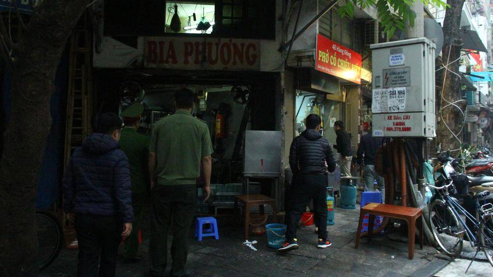 Người d&acirc;n b&ecirc; vội b&aacute;t phở khi tổ c&ocirc;ng t&aacute;c nhắc nhở về việc chủ qu&aacute;n phở k&ecirc; b&agrave;n ghế tr&ecirc;n vỉa h&egrave; ở phố H&agrave;ng Đồng.