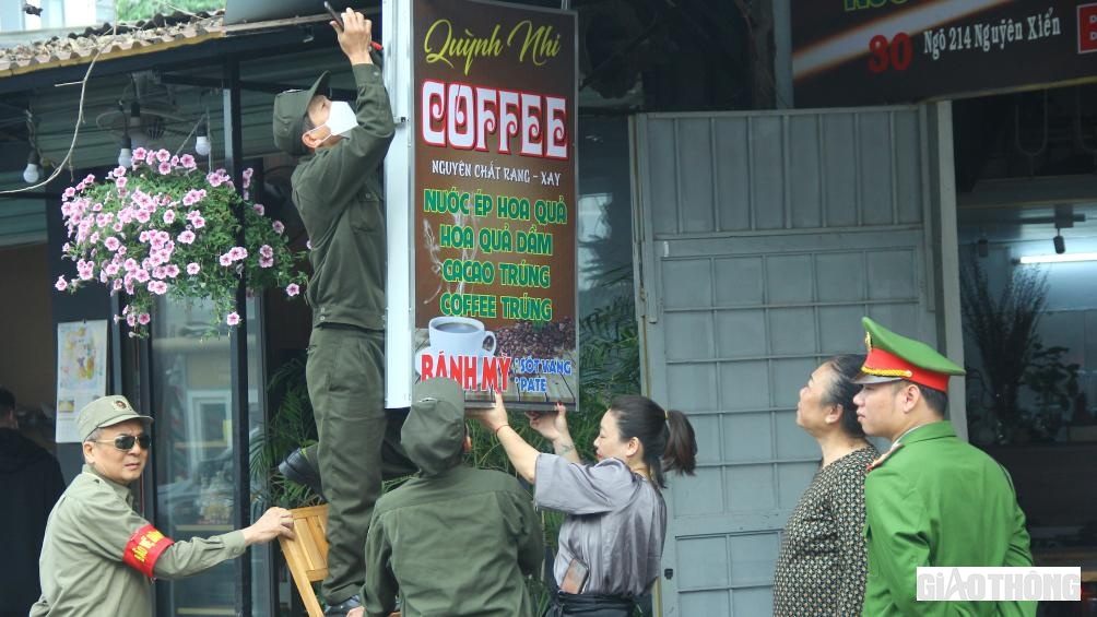Người d&acirc;n tại cửa h&agrave;ng COFFEE "xin" kh&ocirc;ng hạ biển nhưng với sự ki&ecirc;n quyết, tổ c&ocirc;ng t&aacute;c vẫn huy động người để th&aacute;o dỡ.