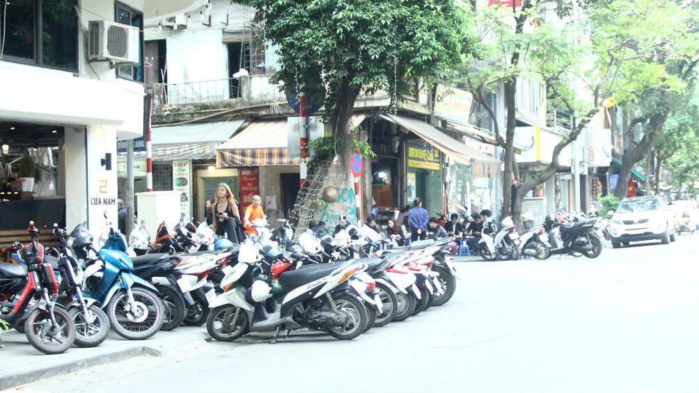 Tại một qu&aacute;n c&agrave; ph&ecirc; ở Cửa Nam, xe m&aacute;y của kh&aacute;ch được đỗ hết tr&ecirc;n vỉa h&egrave;, thậm ch&iacute; c&ograve;n c&oacute; h&agrave;ng d&agrave;i xe m&aacute;y đỗ dưới l&ograve;ng đường.