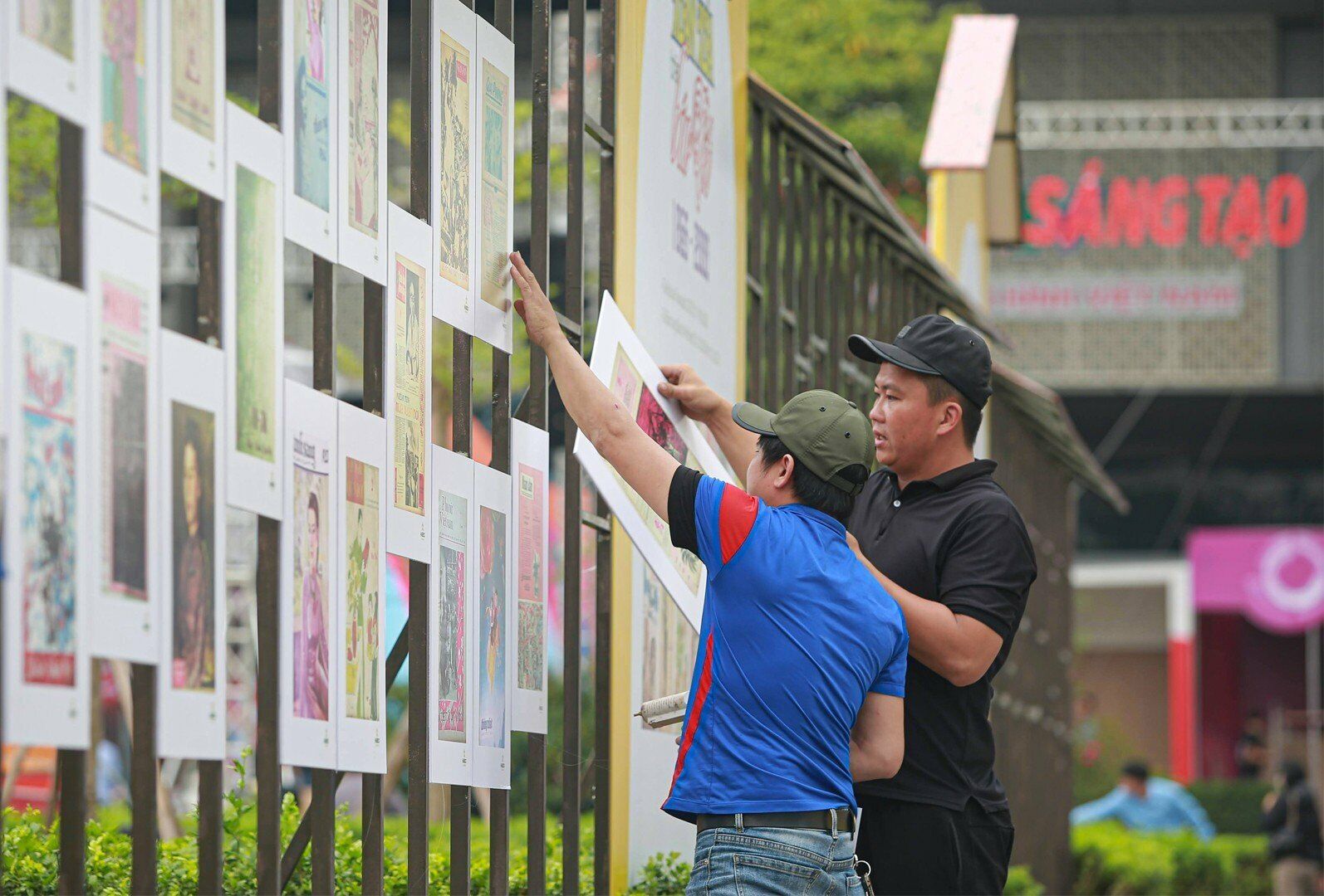 C&aacute;c nh&acirc;n c&ocirc;ng đang lắp đặt, trang tr&iacute; tranh, ảnh dọc theo trục đường cổng ch&iacute;nh v&agrave;o Hội b&aacute;o to&agrave;n quốc 2023.