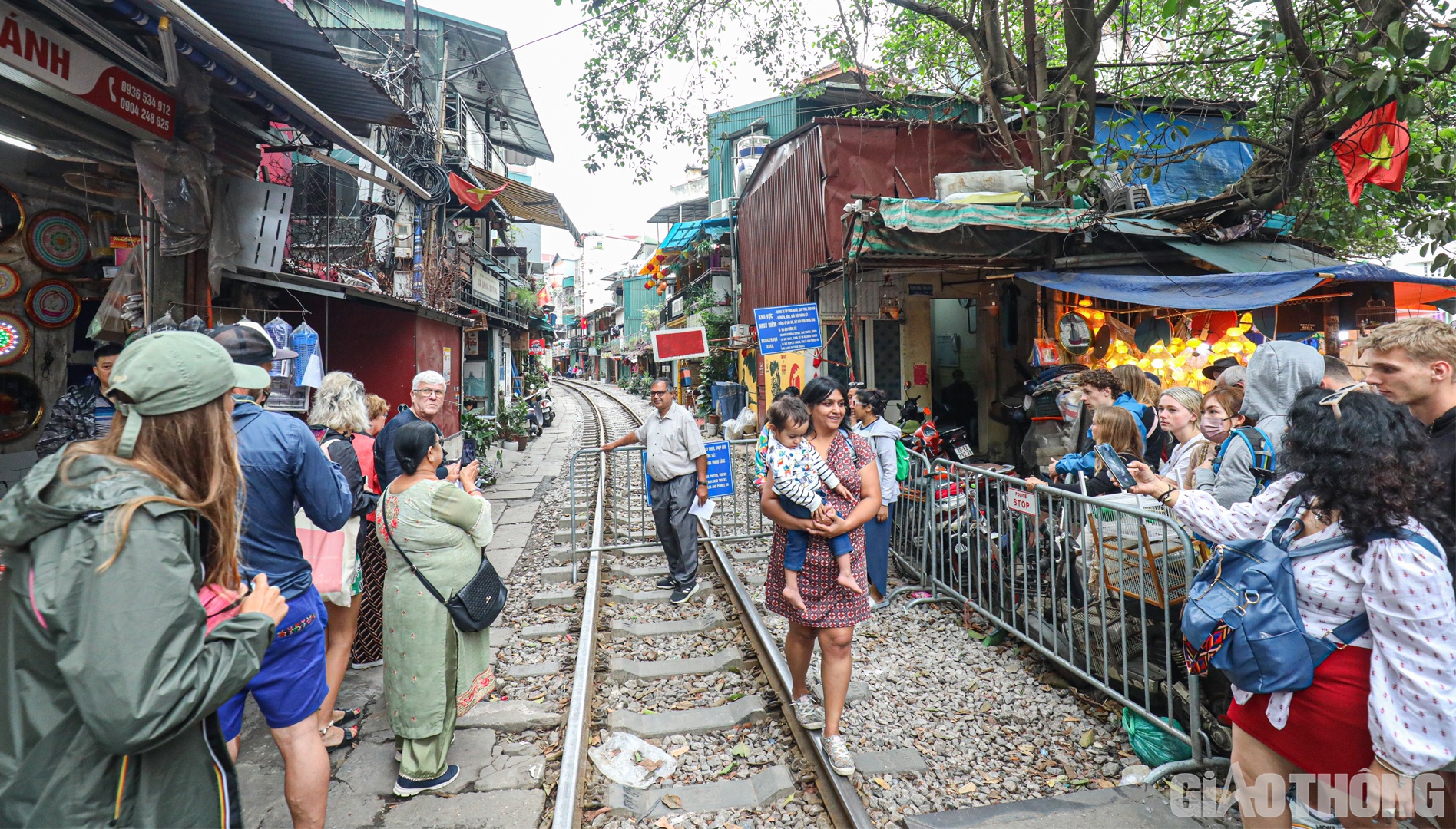 Ghi nhận của PV B&aacute;o Giao th&ocirc;ng trong chiều 26/3, rất đ&ocirc;ng du kh&aacute;ch trong v&agrave; ngo&agrave;i nước đ&atilde; đổ về khu vực  c&oacute; đường sắt giao với đường bộ tr&ecirc;n phố Trần Ph&uacute;, Điện Bi&ecirc;n Phủ để trải nghiệm cảm gi&aacute;c mạo hiểm khi t&agrave;u chạy qua đ&acirc;y.