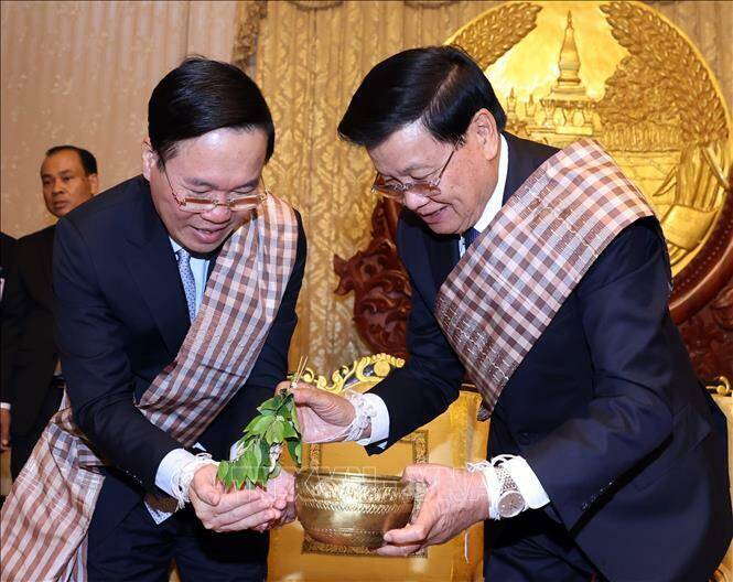 Chủ tịch nước V&otilde; Văn Thưởng v&agrave; Tổng B&iacute; thư, Chủ tịch nước L&agrave;o Thongloun Sisoulith tại lễ buộc chỉ cổ tay cầu may nh&acirc;n dịp Tết cổ truyền Bunpimay của L&agrave;o.