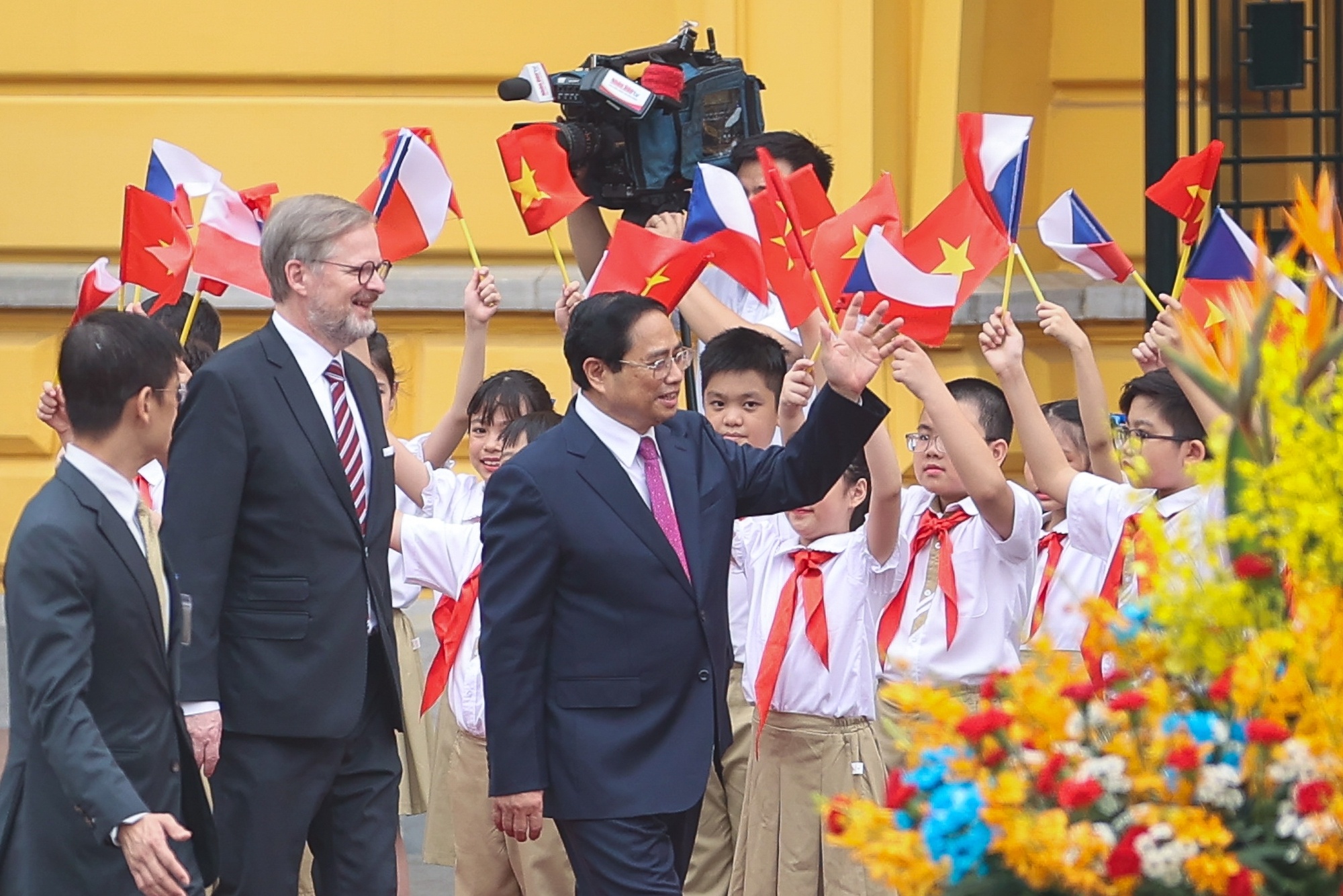 C&aacute;c em học sinh ch&agrave;o mừng Thủ tướng Petr Fiala v&agrave; Thủ tướng Phạm Minh Ch&iacute;nh - Ảnh: VGP/Nhật Bắc