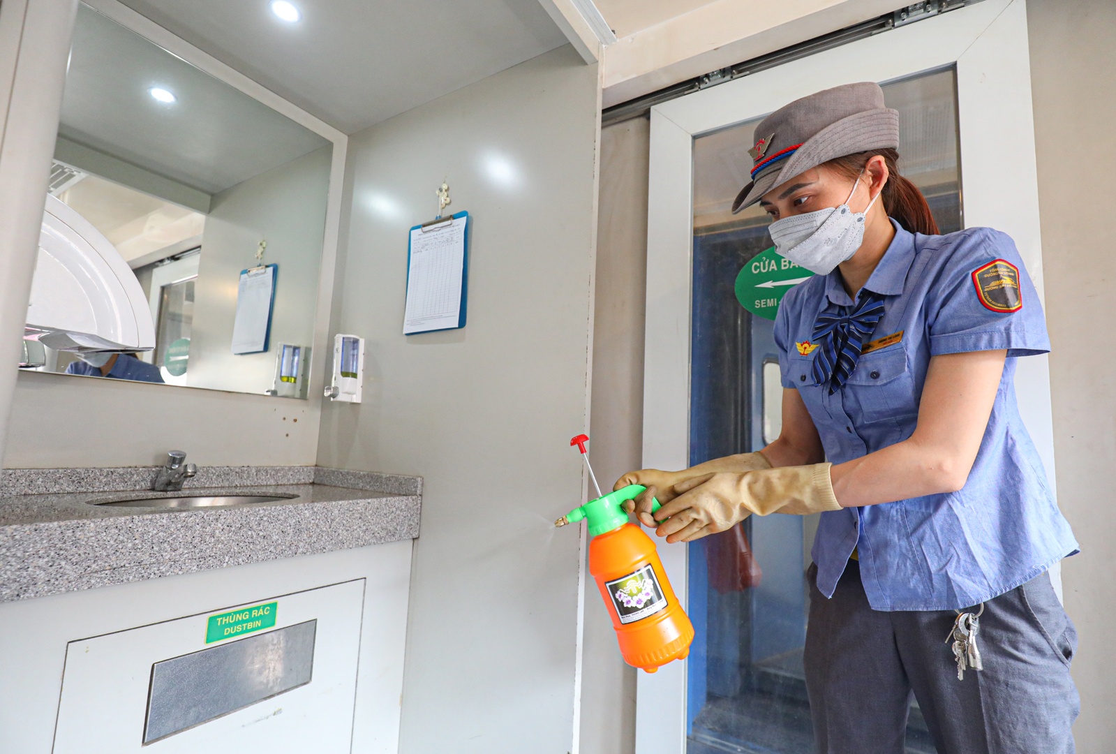 Kh&ocirc;ng chỉ c&aacute;c trang thiết bị trực tiếp phục vụ h&agrave;nh kh&aacute;ch, đường sắt c&ograve;n tăng cường c&ocirc;ng t&aacute;c vệ sinh, c&ocirc;ng t&aacute;c ph&ograve;ng dịch Covid-19. Đo&agrave;n Tiếp vi&ecirc;n đường sắt H&agrave; Nội y&ecirc;u cầu nh&acirc;n vi&ecirc;n tr&ecirc;n c&aacute;c đo&agrave;n t&agrave;u đeo khẩu trang v&agrave; nhắc nhở h&agrave;nh kh&aacute;ch đeo khẩu trang tr&ecirc;n h&agrave;nh tr&igrave;nh. Nh&acirc;n vi&ecirc;n phải thường xuy&ecirc;n thu dọn vệ sinh, khử khuẩn tr&ecirc;n t&agrave;u tại c&aacute;c vị tr&iacute; thường xuy&ecirc;n tiếp x&uacute;c như mặt b&agrave;n, tay nắm cửa... (Ảnh: Vệ sinh vi&ecirc;n tr&ecirc;n t&agrave;u xịt khử khuẩn khu vực rửa mặt, chuẩn bị x&agrave; ph&ograve;ng rửa tay)