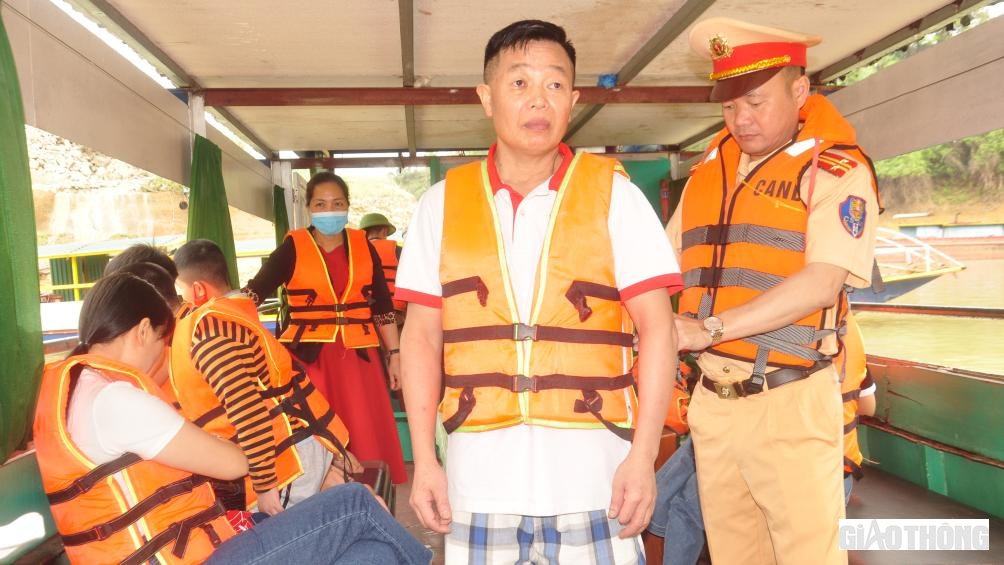 Đội CSGT đường thủy, Ph&ograve;ng CSGT, C&ocirc;ng an tỉnh Y&ecirc;n B&aacute;i hướng dẫn người d&acirc;n mặc &aacute;o phao, dụng cụ nổi nhằm đảm bảo an to&agrave;n khi đi du lịch tr&ecirc;n hồ Th&aacute;c B&agrave;