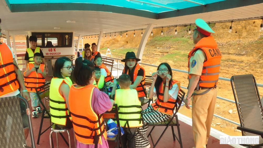 Lực lượng CSGT đường thủy tuy&ecirc;n truyền, nhắc nhở, hướng dẫn người d&acirc;n, du kh&aacute;ch đảm bảo an to&agrave;n khi tham gia giao th&ocirc;ng tr&ecirc;n hồ Th&aacute;c B&agrave;