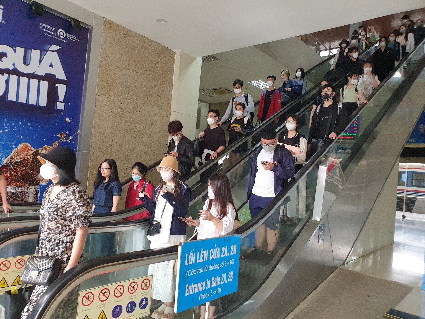 Do t&agrave;u đỗ tại c&aacute;c đường ke ga ph&iacute;a trong n&ecirc;n h&agrave;nh kh&aacute;ch phải đi theo cầu vượt bộ h&agrave;nh, xuống cầu thang cuốn ra ga