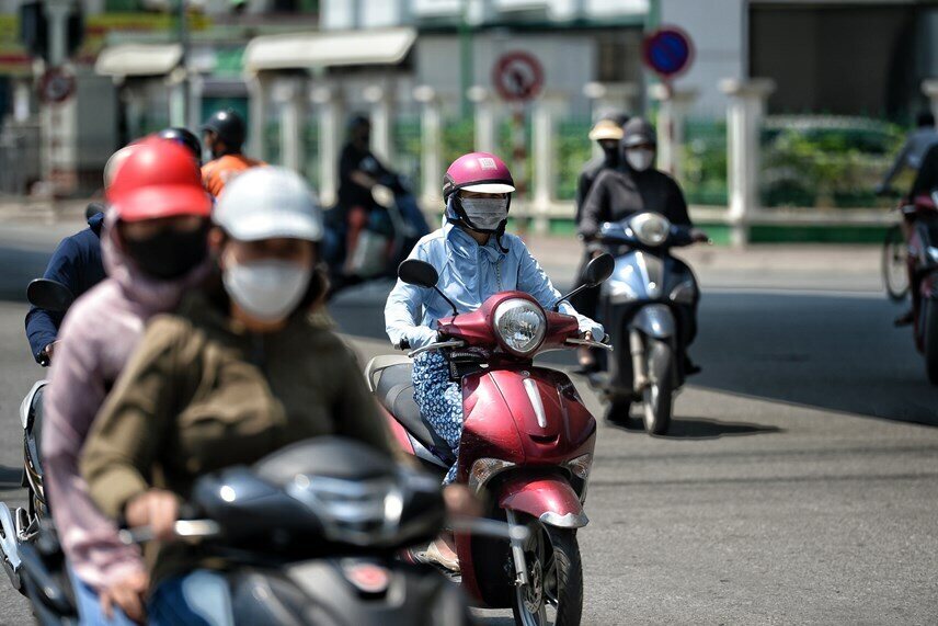 Những người di chuyển tr&ecirc;n đường bằng xe m&aacute;y đ&atilde; sử dụng &aacute;o chống nắng tr&ugrave;m k&iacute;n người để tr&aacute;nh c&aacute;i nắng bỏng r&aacute;t.