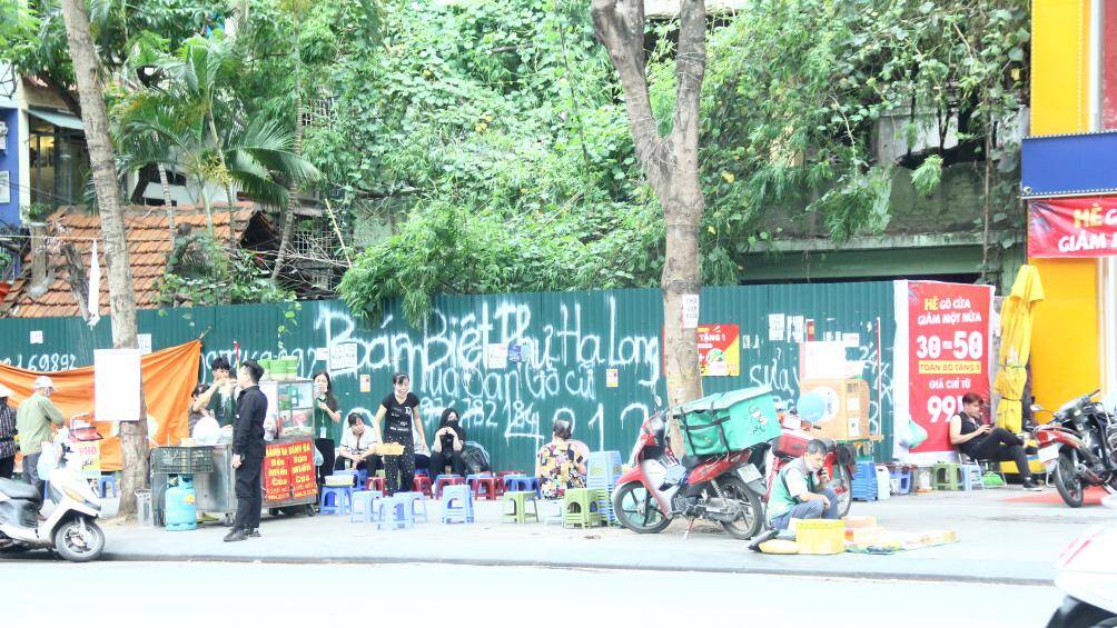 Sau khi H&agrave; Nội triển khai cao điểm "gi&agrave;nh lại vỉa h&egrave; cho người đi bộ", những ng&agrave;y trung tuần th&aacute;ng 5, PV B&aacute;o Giao th&ocirc;ng ghi nhận, nhiều vỉa h&egrave;, l&ograve;ng đường ở c&aacute;c tuyến phố ở H&agrave; Nội vẫn bị chiếm dụng l&agrave;m nơi kinh doanh, bu&ocirc;n b&aacute;n, tr&ocirc;ng giữ xe... Ảnh: Qu&aacute;n tr&agrave; đ&aacute;, b&aacute;nh m&igrave; bao trọn vỉa h&egrave; tr&ecirc;n đường Th&aacute;i H&agrave;.