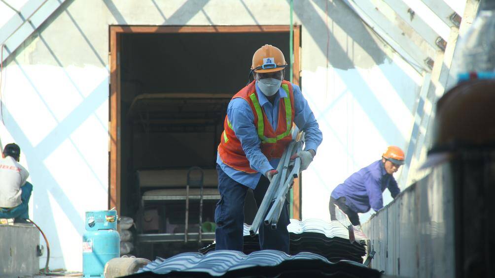 Những tấm t&ocirc;n, thanh th&eacute;p được c&aacute;c c&ocirc;ng nh&acirc;n xếp gọn g&agrave;ng rồi chuyển l&ecirc;n xe &ocirc; t&ocirc; để chở đi.