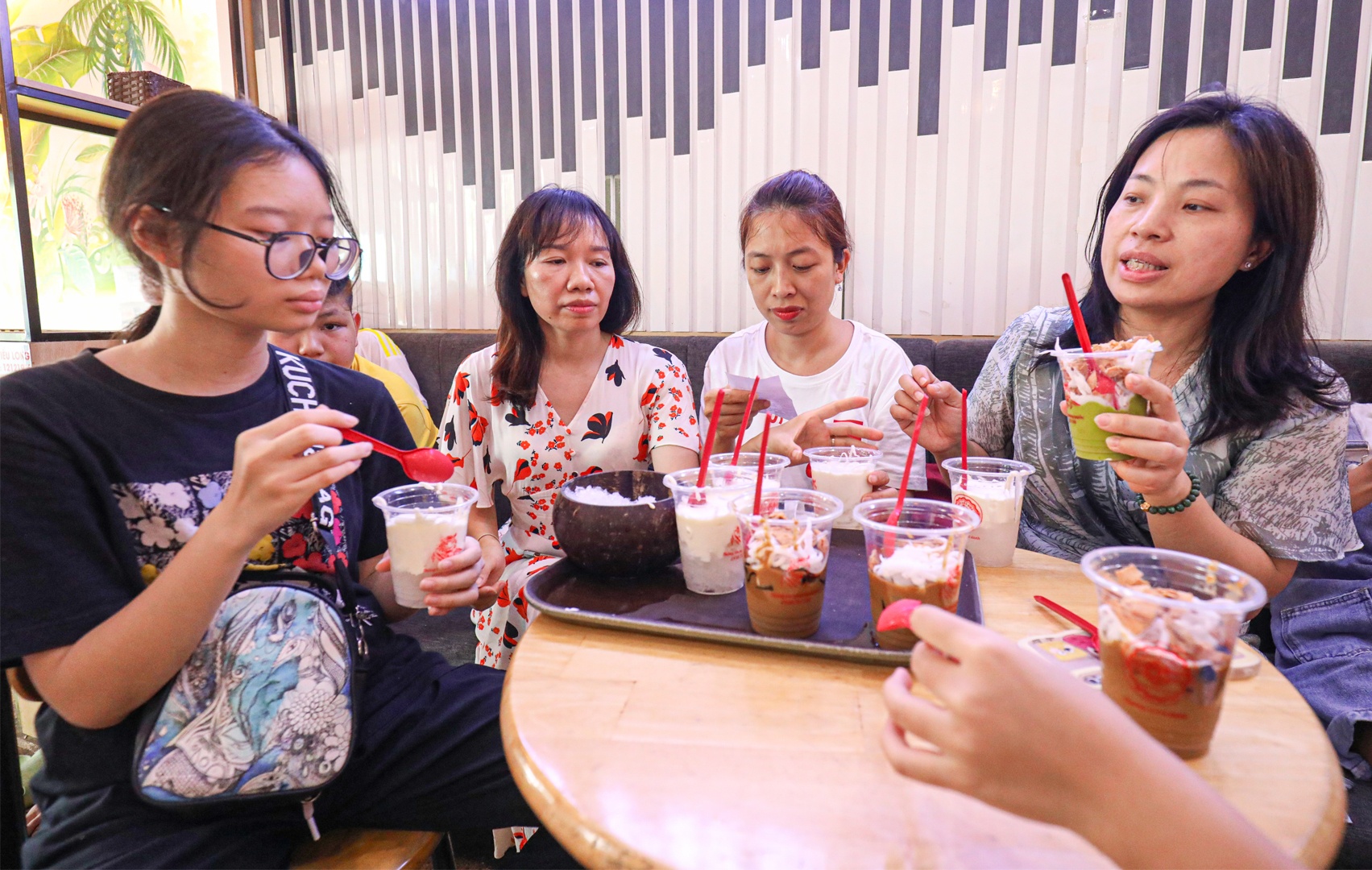 Check in các điểm tham quan xong, khách có thể đi thưởng thức các món ăn vặt nổi tiếng của Hải Phòng: Chả nem hải sản, ốc xào, bánh đa cua, bún hải sản, bánh bèo, bánh đúc tôm thịt hay giá biển xào, cà phê cốt dừa, chè dừa dầm... Ảnh: Khách thưởng thức cà phê cốt dừa