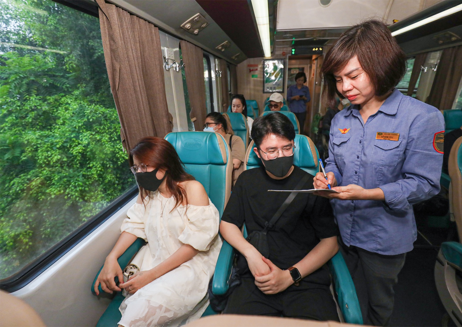 Theo Trưởng tàu Việt, do ngày đầu tuần nên tàu không kín phương án vé, dù chỉ có 6 toa xe khách. Vào ngày cuối tuần, tàu đặc biệt đông khách, ngoài lượng khách chủ yếu đi food tour còn khách đi thăm thân, đi công việc. Các chuyến tàu đều nối thêm toa xe nhưng vẫn kín chỗ, có chuyến lên đến 1.000 hành khách. Hành khách có thể mang theo xe máy gửi lên tàu, giá khoảng 120.000 đồng/xe/lượt để di chuyển ở Hải Phòng. Nếu không, có thể thuê ngay tại khu vực cửa ga. Ảnh: Nhân viên trên tàu đến hỏi các hành khách xem có nhu cầu thuê xe máy, xe điện không để kết nối giúp hành khách.