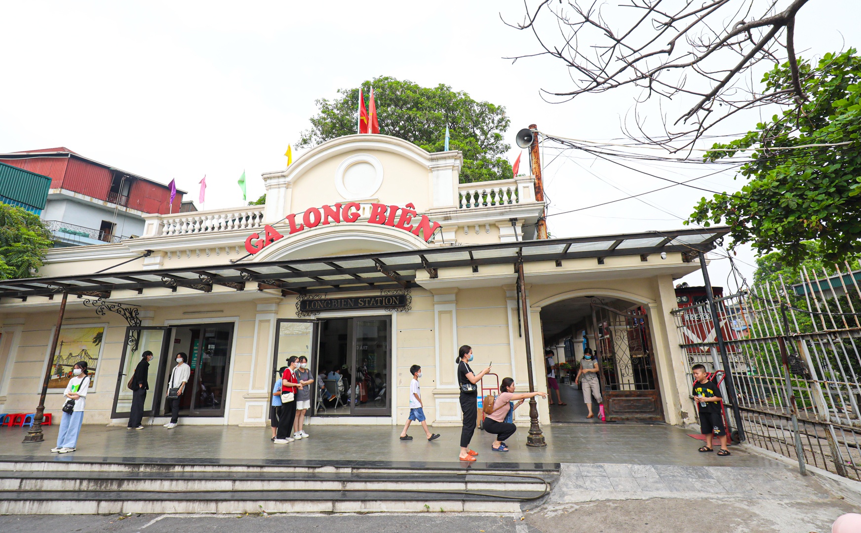 Để đến ph&ograve;ng đợi t&agrave;u mới, kh&aacute;ch c&oacute; thể đi từ ph&iacute;a cổng ch&iacute;nh ga Long Bi&ecirc;n. Tại đ&acirc;y, kh&aacute;ch c&oacute; thể chụp ảnh check-in nh&agrave; ga đ&atilde; được cải tạo theo phong c&aacute;ch kiến tr&uacute;c thời Ph&aacute;p thuộc. Kh&aacute;nh th&agrave;nh v&agrave; hoạt động từ năm 1902, ga Long Bi&ecirc;n c&ograve;n c&oacute; t&ecirc;n gọi l&agrave; ga Đầu Cầu do chỉ nằm c&aacute;ch cầu Long Bi&ecirc;n v&agrave;i m&eacute;t. To&agrave;n bộ khu nh&agrave; ch&iacute;nh của ga được đặt tr&ecirc;n c&aacute;c v&ograve;m đ&aacute; hộc của cầu dẫn t&agrave;u hỏa chạy dọc phố Gầm Cầu. Nh&agrave; ga thực sự l&agrave; một điểm dừng ch&acirc;n đặc sắc trong h&agrave;nh tr&igrave;nh kh&aacute;m ph&aacute; H&agrave; Nội.