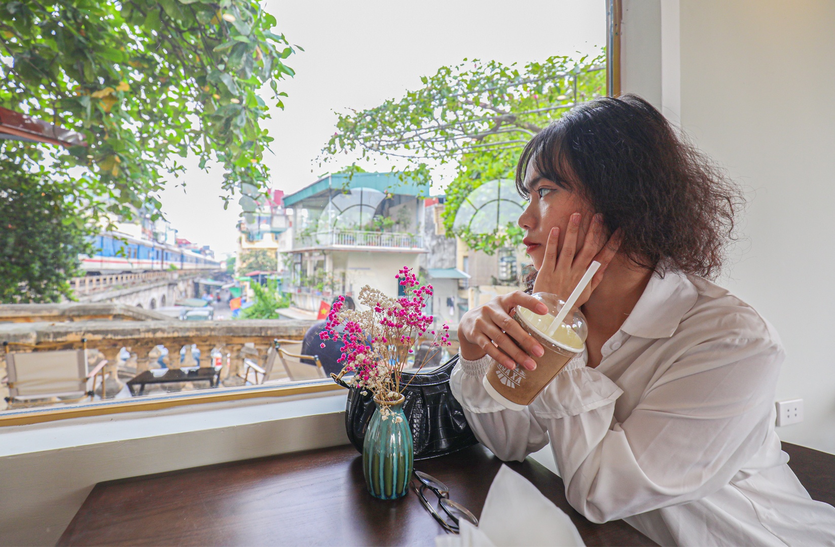 Trong l&uacute;c đợi t&agrave;u xuất ph&aacute;t, kh&aacute;ch c&oacute; thể sử dụng dịch vụ c&agrave; ph&ecirc; trong ph&ograve;ng đợi. Bạn Nguy&ecirc;n Quỳnh (quận Đống Đa, H&agrave; Nội) cho biết, nh&oacute;m bạn của bạn rất th&iacute;ch th&uacute; với điểm check-in mới n&agrave;y, rất độc, lạ, vừa c&oacute; thể thưởng thức c&agrave; ph&ecirc;, vừa c&oacute; thể chụp ảnh. &ldquo;Kh&ocirc;ng gian khu vực n&agrave;y rộng, rất chill, lại an to&agrave;n v&igrave; c&oacute; h&agrave;ng r&agrave;o ngăn với đường sắt, c&oacute; nh&acirc;n vi&ecirc;n nh&agrave; ga canh an to&agrave;n. Đặc biệt khi ngắm nh&igrave;n t&agrave;u chạy rời ga, c&oacute; cảm gi&aacute;c b&acirc;ng khu&acirc;ng rất kh&oacute; tả. Chắc chắn em sẽ c&ograve;n đến đ&acirc;y tiếp&rdquo;, bạn Quỳnh chia sẻ.