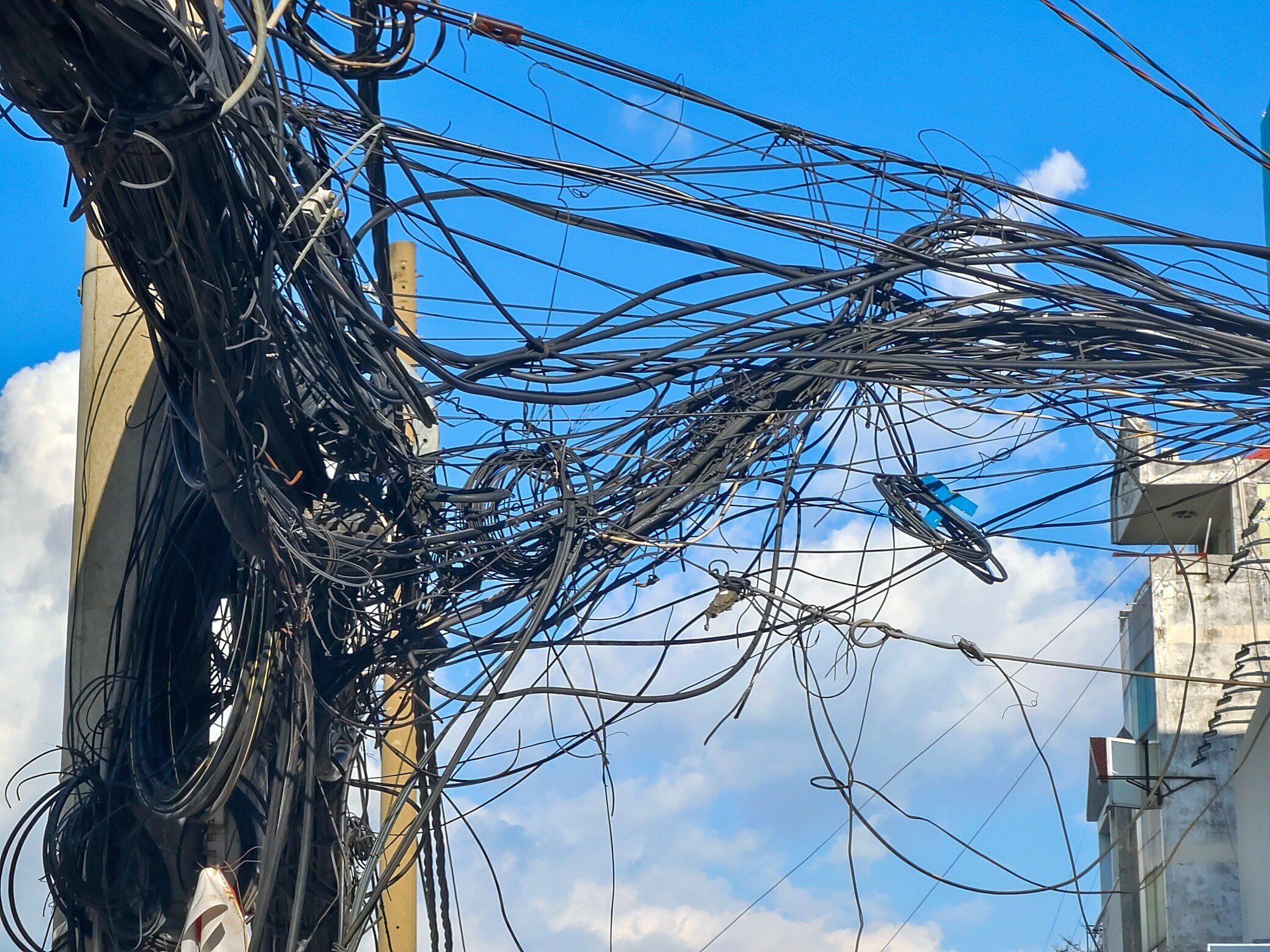 Trong ảnh l&agrave; c&aacute;c trụ, d&acirc;y c&aacute;p điện chưa được di dời sau khi mặt bằng được dỡ bỏ.